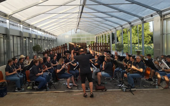 Das Gesamtorchester spielt im Gewächshaus, der Dirigent steht vorne