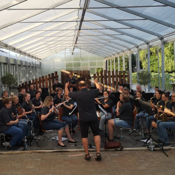 Das Gesamtorchester spielt im Gewächshaus, der Dirigent steht vorne